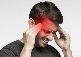 Young male experiencing pressure and placing his fingers towards his head